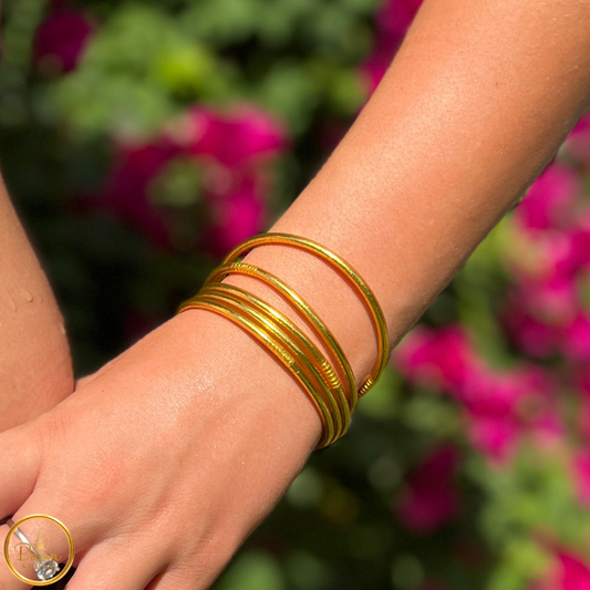 Cinq joncs bouddhistes Kumlai fins couleur or portés au poignet – Bâan Kumlaï