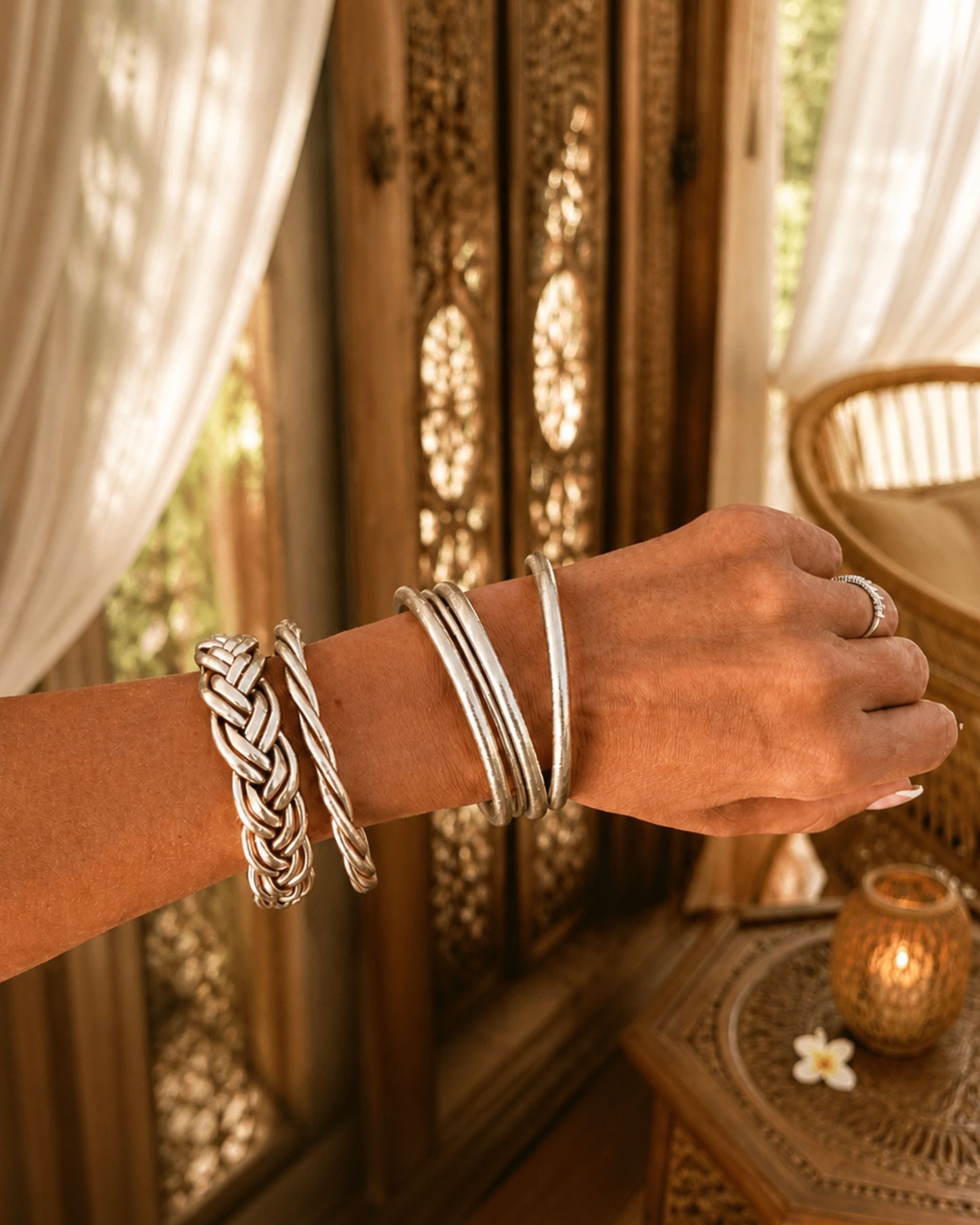 Bracelet Kumlai or rose tressé porté en accumulation avec d’autres bracelets bouddhistes Bâan Kumlaï