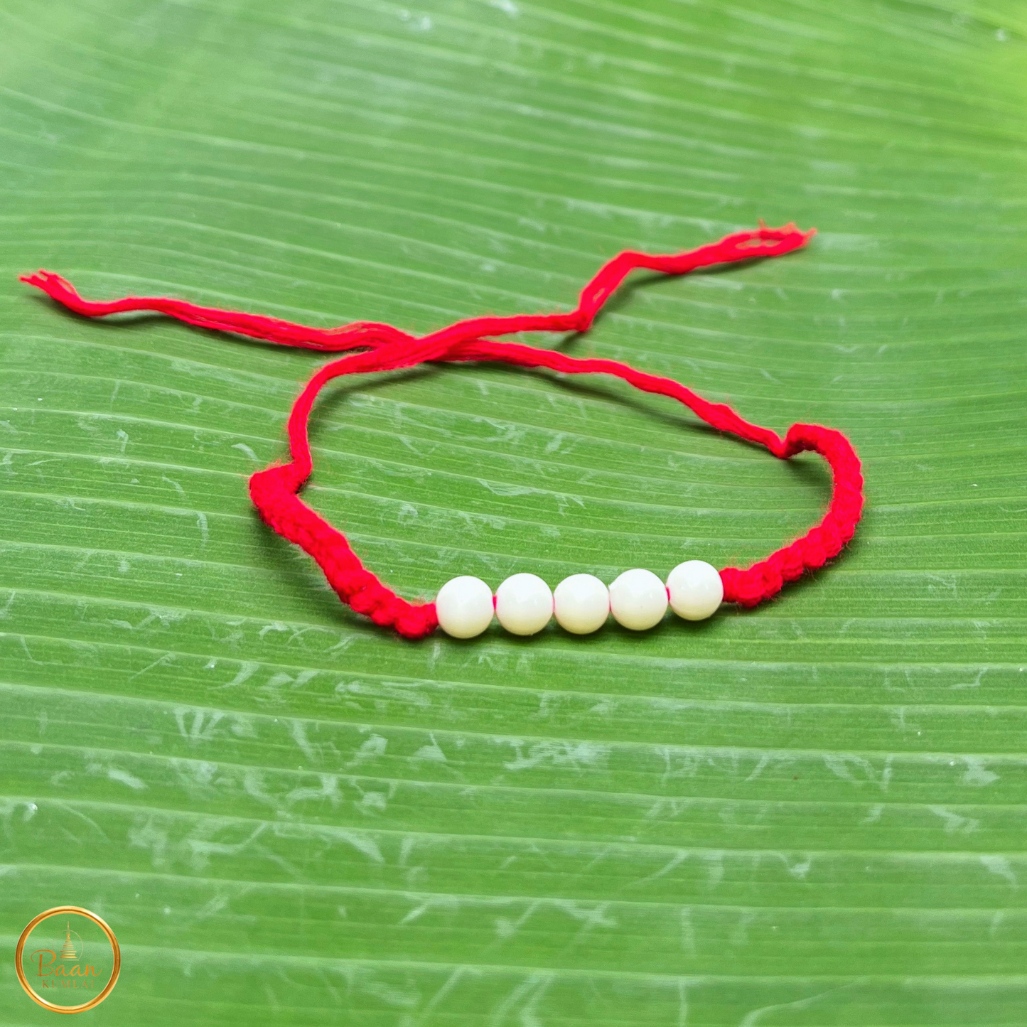 Bracelet rouge sacré bouddhiste Sai Sin béni par les moines, fil porte-bonheur à nouer avec prière pour protection et chance.