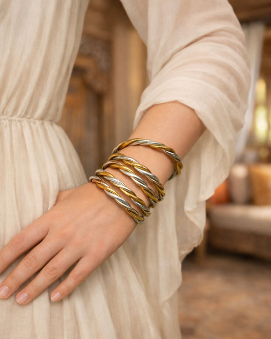 Jonc bouddhiste torsadé 3 couleurs Bâan Kumlaï porté au poignet avec une robe blanche, bracelet Kumlai élégant