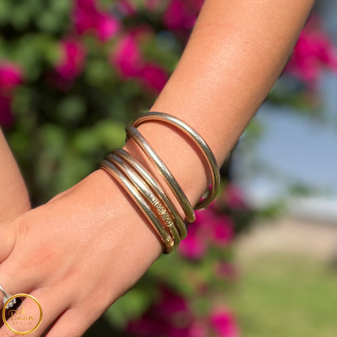 Cinq joncs bouddhistes Kumlai couleur or rose portés au poignet – Bâan Kumlaï