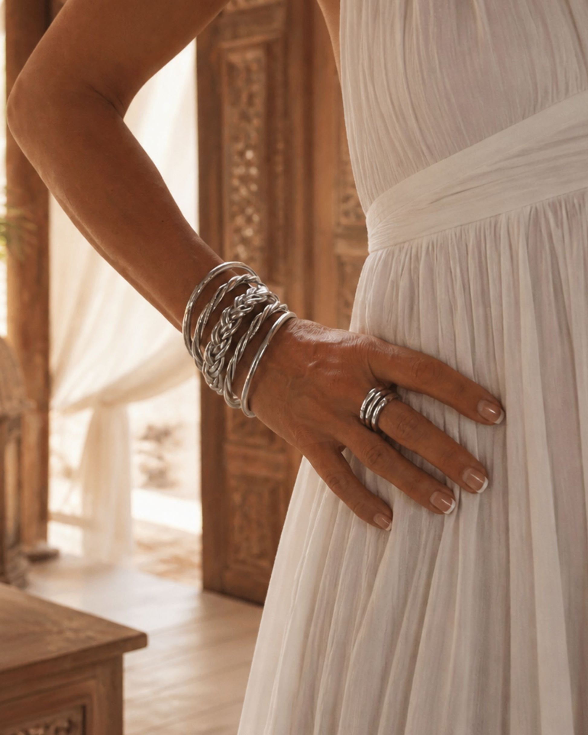 Bagues Kumlai argent portées avec bracelets bouddhistes argent Bâan Kumlaï sur robe blanche.
