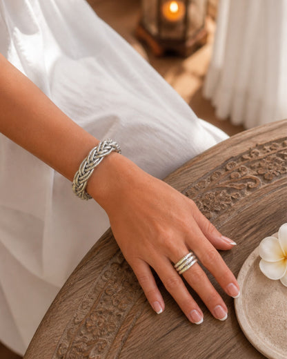 Bracelet Kumlai argent tressé porté au poignet avec bague assortie, dans un univers élégant et naturel.