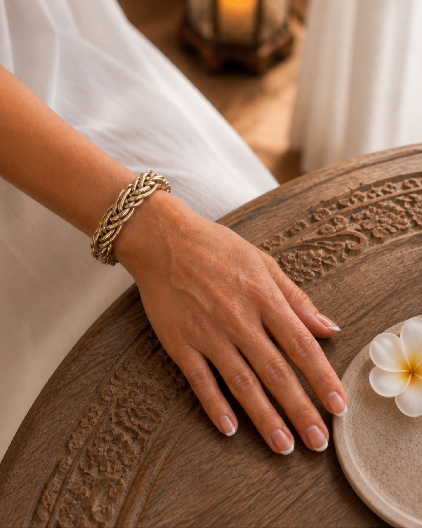 Bracelet Kumlai or rose tressé porté au poignet, dans un univers chaleureux et naturel.
