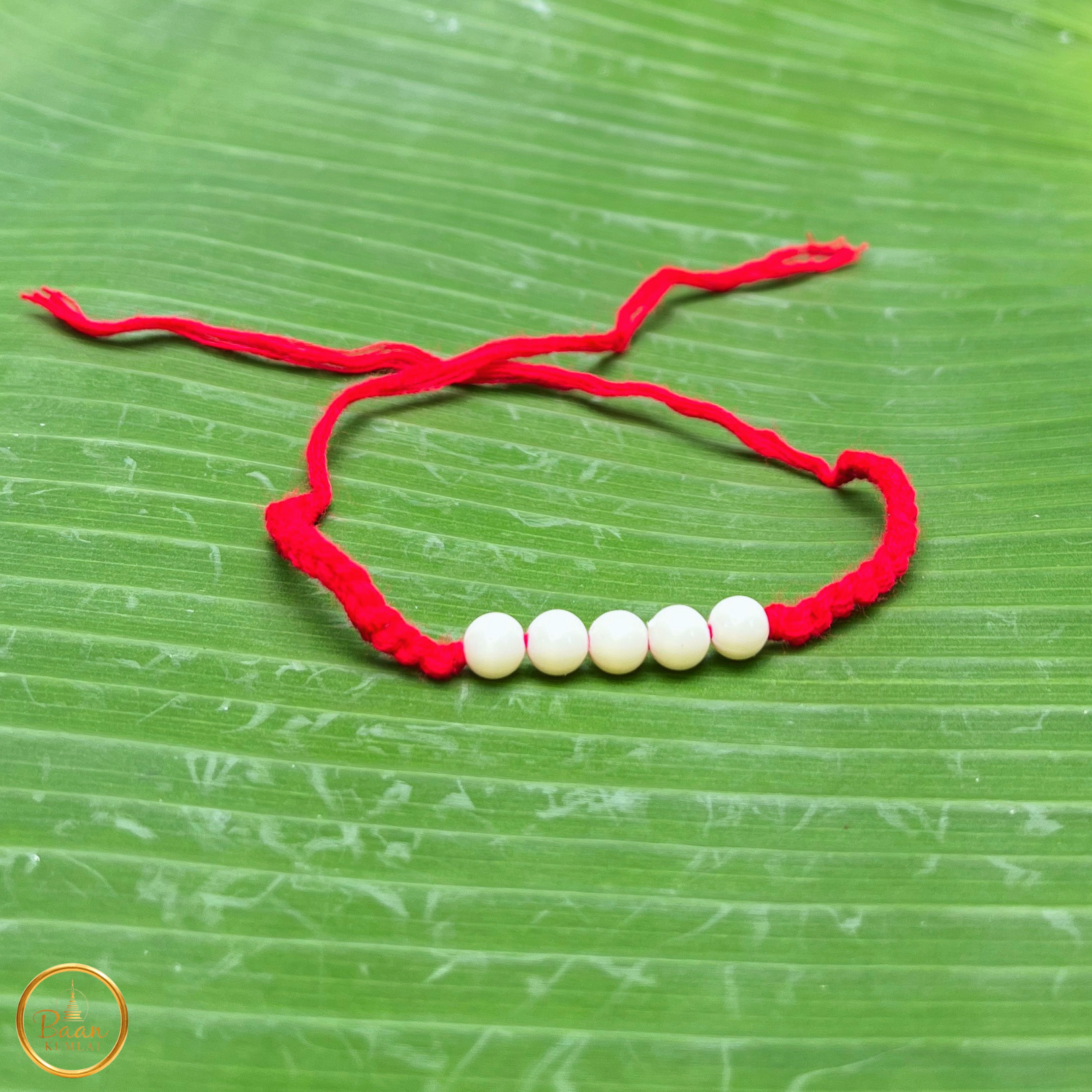 Bracelet rouge sacré bouddhiste Sai Sin béni par les moines, fil porte-bonheur à nouer avec prière pour protection et chance.