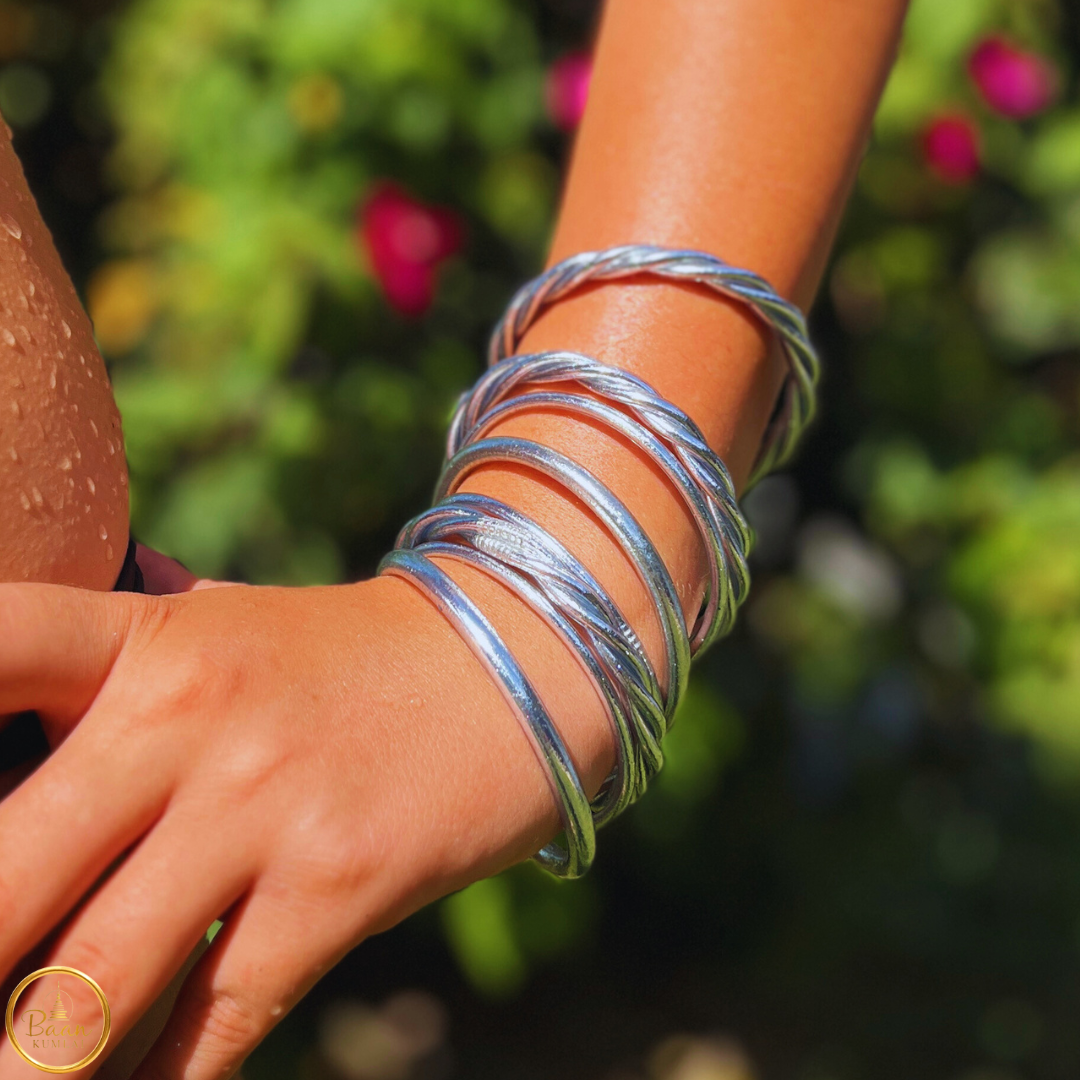 Poignet portant sept joncs bouddhistes en argent, mélange de joncs torsadés et fins Bâan Kumlaï