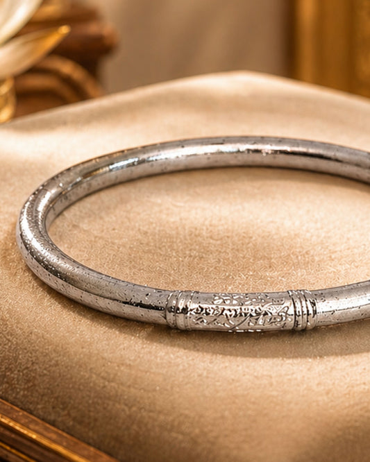 Détail du jonc bouddhiste argent Bâan Kumlaï avec mantra gravé et feuilles d’argent visibles en transparence