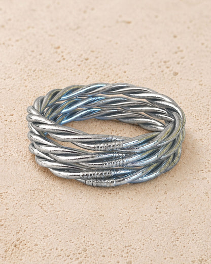 Jonc bouddhiste argent torsadé Bâan Kumlaï sur fond minéral chaud, bracelet Kumlai argenté fabriqué en Thaïlande