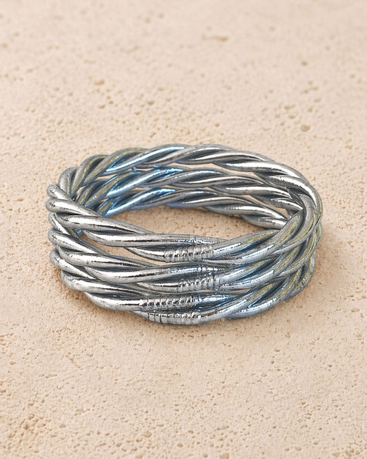 Jonc bouddhiste argent torsadé Bâan Kumlaï sur fond minéral chaud, bracelet Kumlai argenté fabriqué en Thaïlande