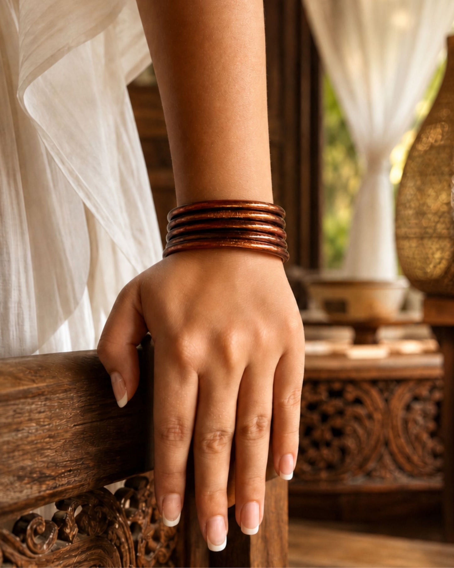 Joncs bouddhistes chocolat Bâan Kumlaï portés avec une robe blanche, rendu féminin et raffiné