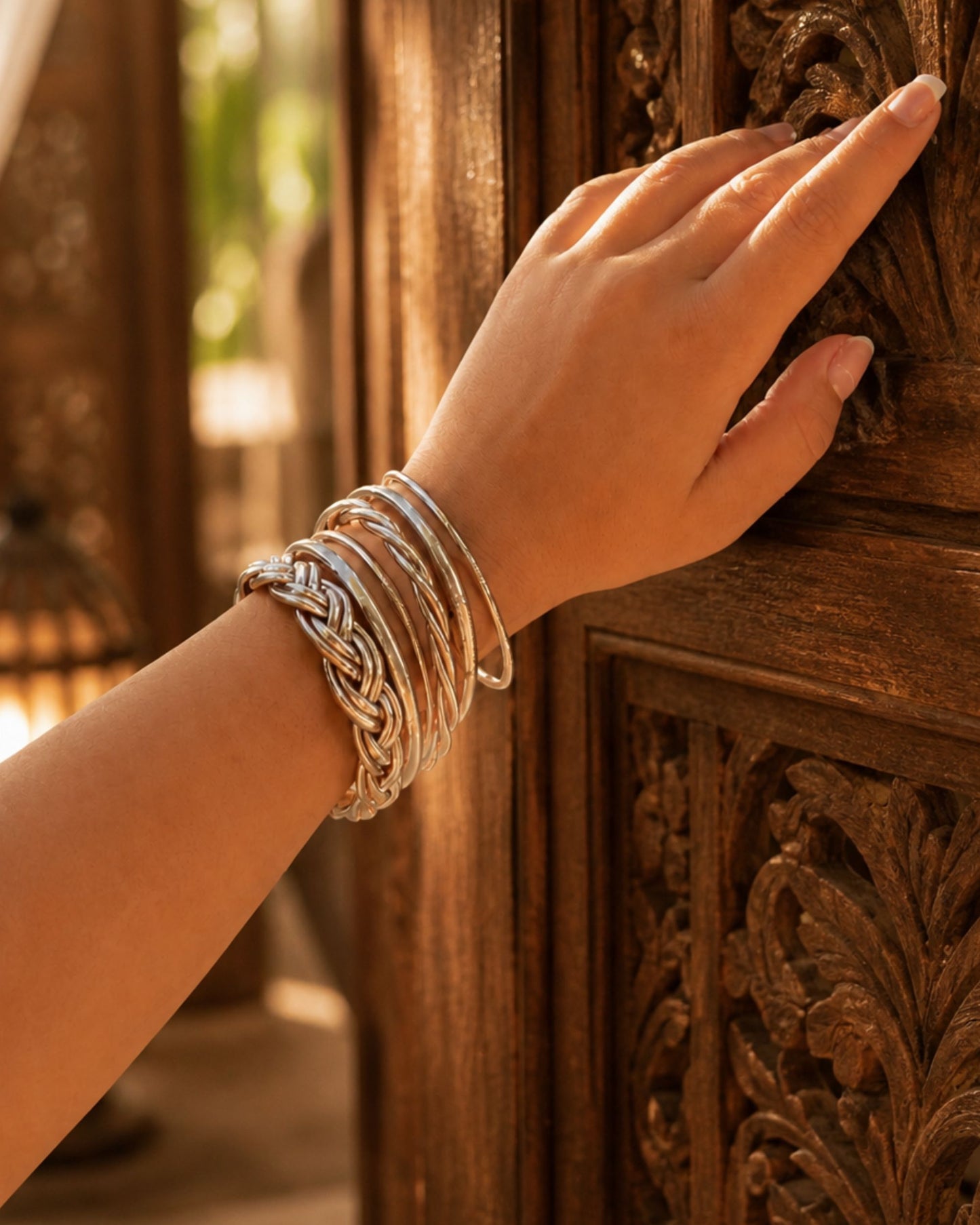 Association de joncs Bâan Kumlaï avec jonc bouddhiste or rose fin porté au poignet, mix élégant de modèles dans un décor bohème chic.
