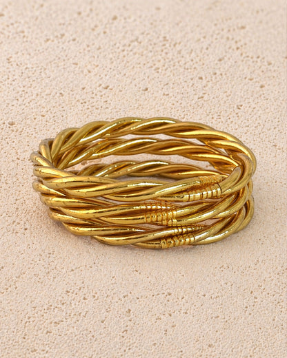 Jonc bouddhiste or torsadé Bâan Kumlaï sur fond minéral chaud, bracelet Kumlai doré fabriqué en Thaïlande