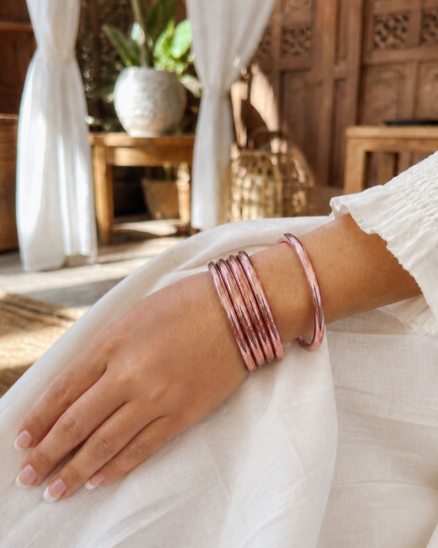 Bracelets Kumlai rose poudré Bâan Kumlaï portés au poignet, accumulation chic de joncs bouddhistes rose