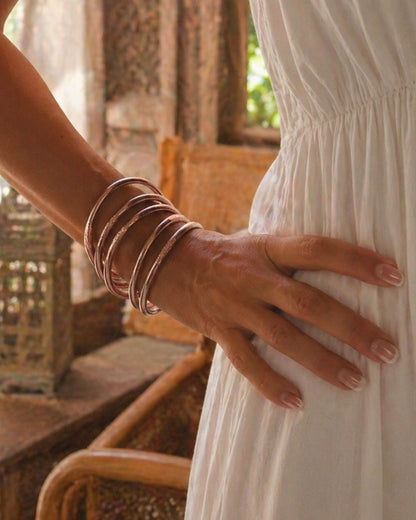 Joncs bouddhistes rose poudré Bâan Kumlaï portés avec une robe blanche, look féminin et lumineux